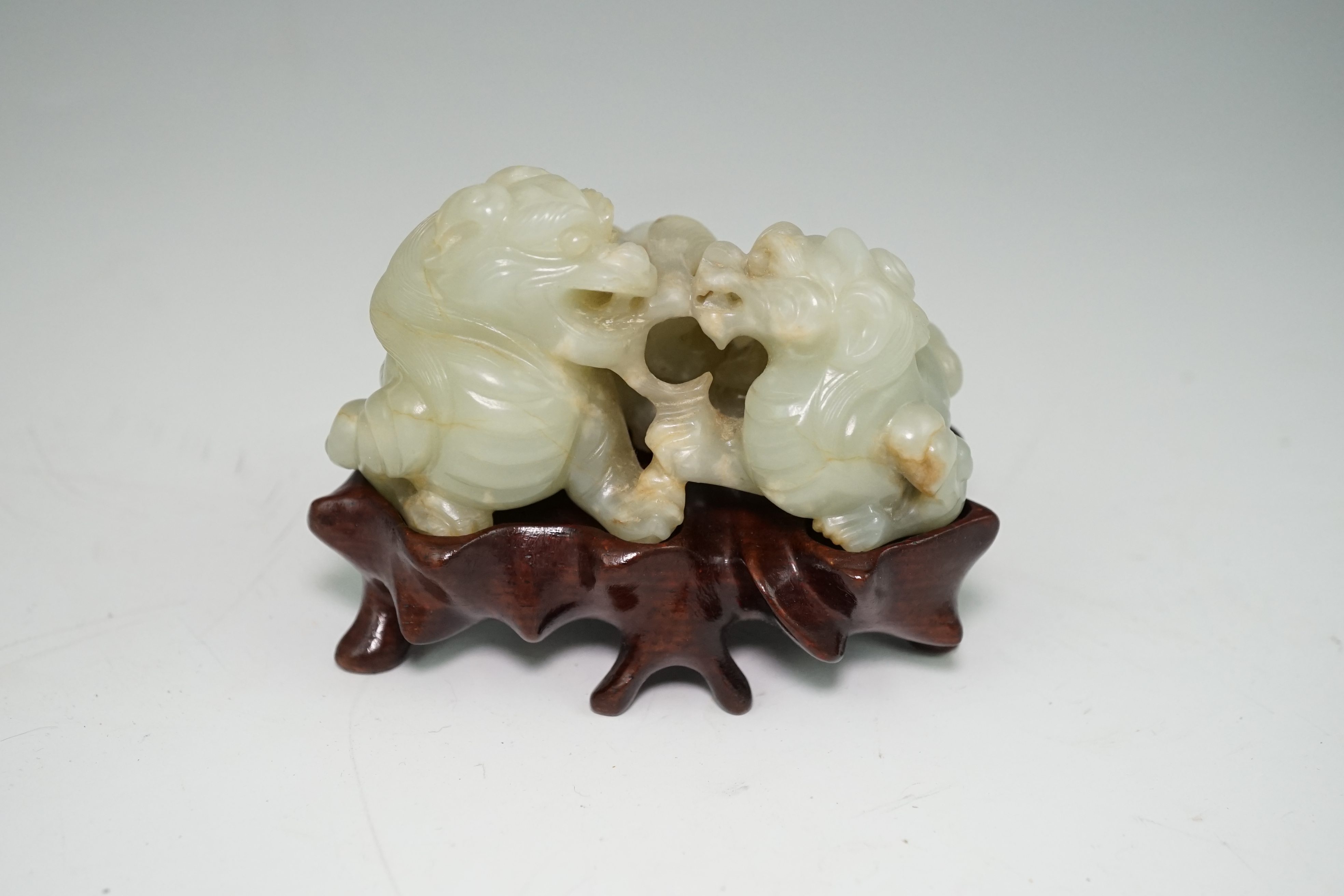 A Chinese celadon and russet jade group of two lion-dogs, 19th century